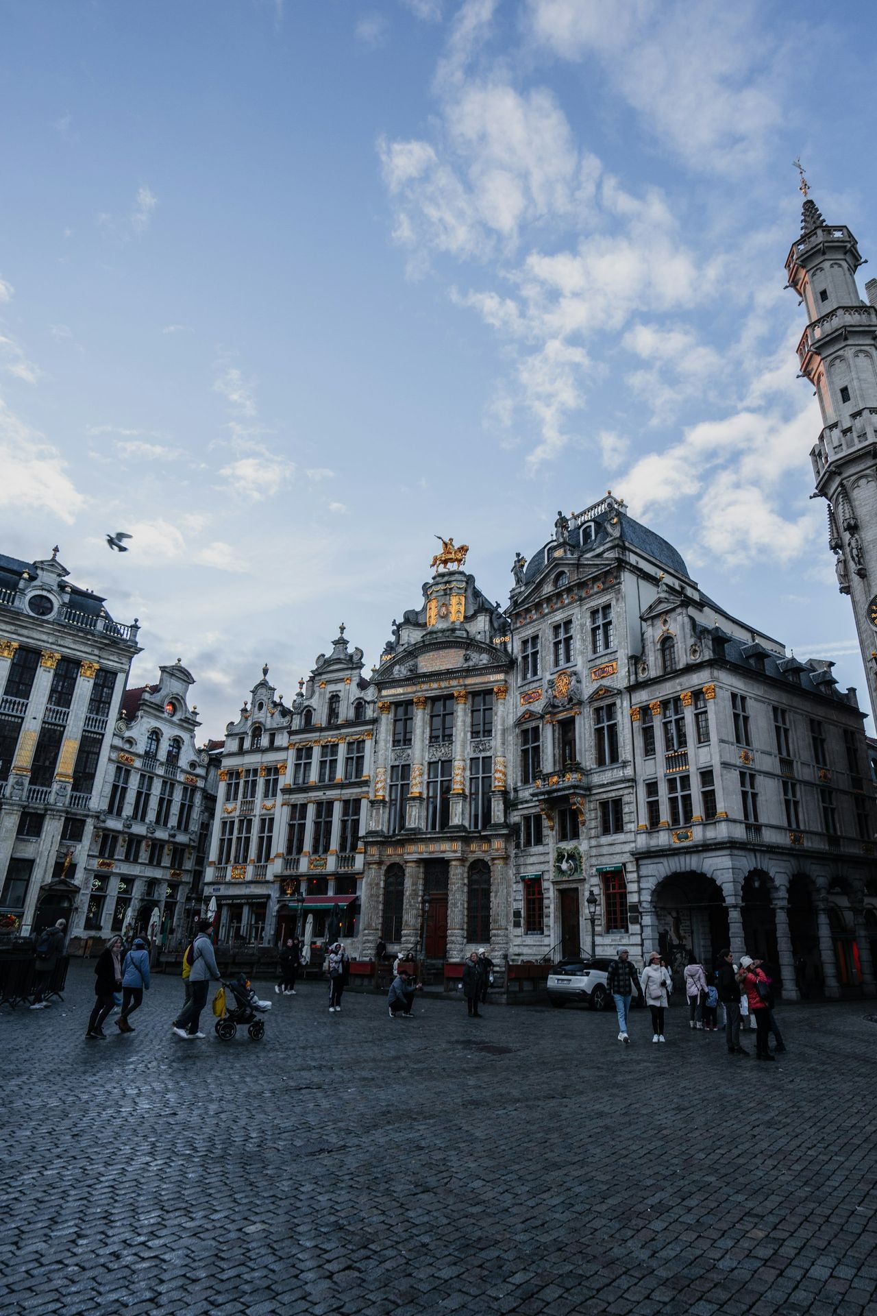 a group of people walking around a cobblestone street